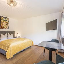 Geräumiges Schlafzimmer mit Tisch und Stühlen.