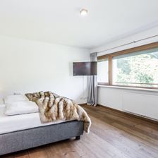 Schlafzimmer mit Doppelbett und Blick in den Garten