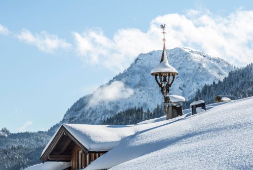 PillerseeTal: verschneites Bauernhaus mit Glockenstuhl